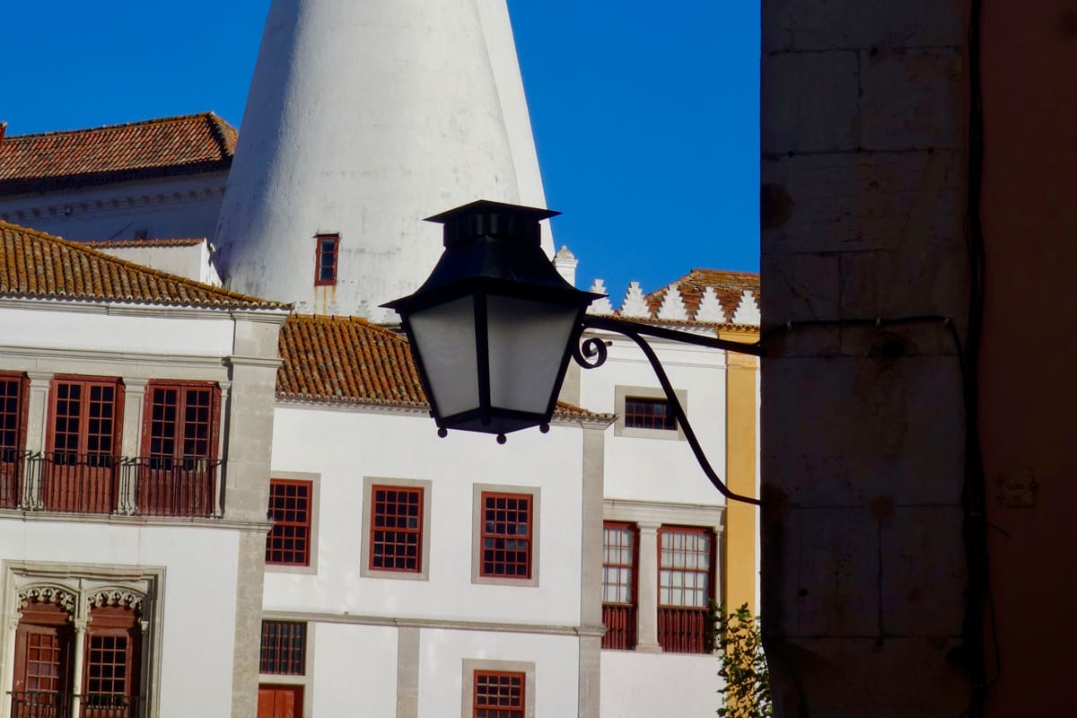 The Palácio Nacional de Sintra (Sintra National Palace) with its signature twin white conical kitchen chimneys rising above the old town of Sintra, Portugal. UNESCO World Heritage since 1995.
